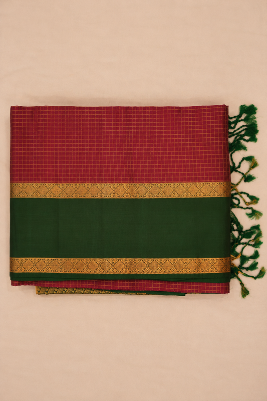 Elegant wine-maroon pure soft silk with a striking dark green border enriched with intricate gold zari diamond motifs.