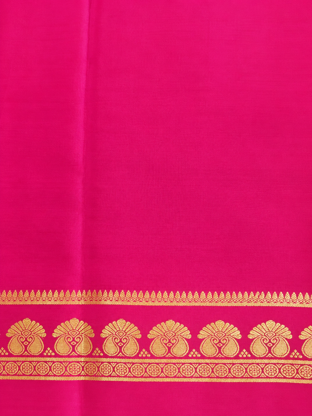 Elegant wine-maroon Mysore Crepe silk enriched with traditional gold zari and graceful twin-peacock-inspired border motifs.