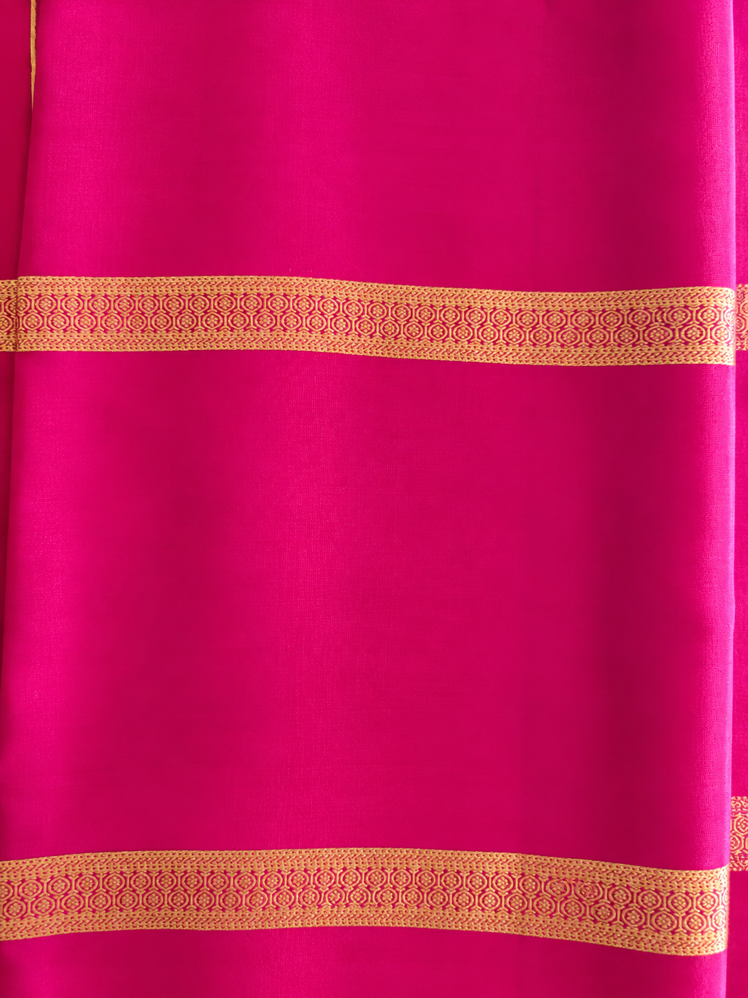 Rich magenta Mysore Crepe silk adorned throughout with Peacock, Gandaberunda, Topi and Elephant motifs in exquisite gold zari.