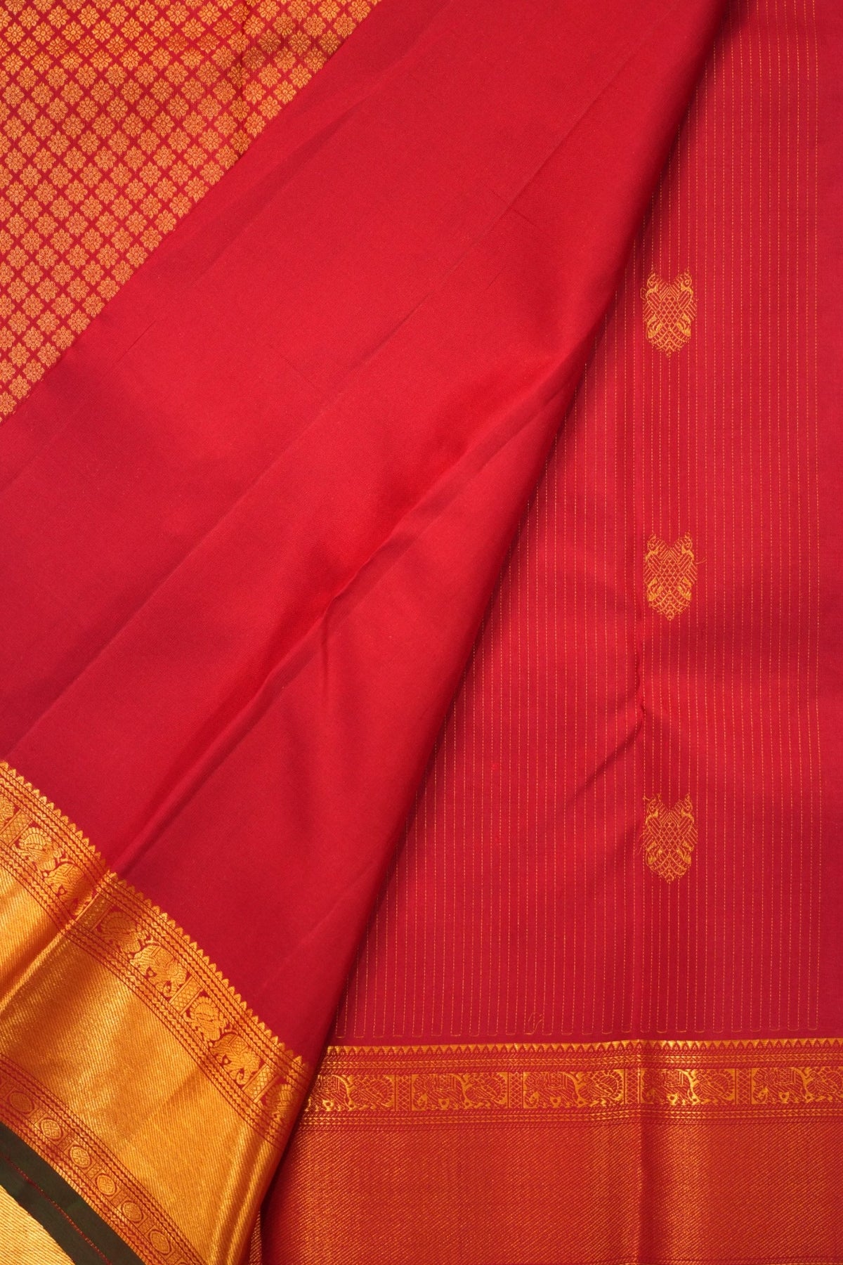 Rich deep crimson red Kanjivaram silk adorned with Gandaberunda motifs, peacocks, elephants and Rudraksha zari detailing.