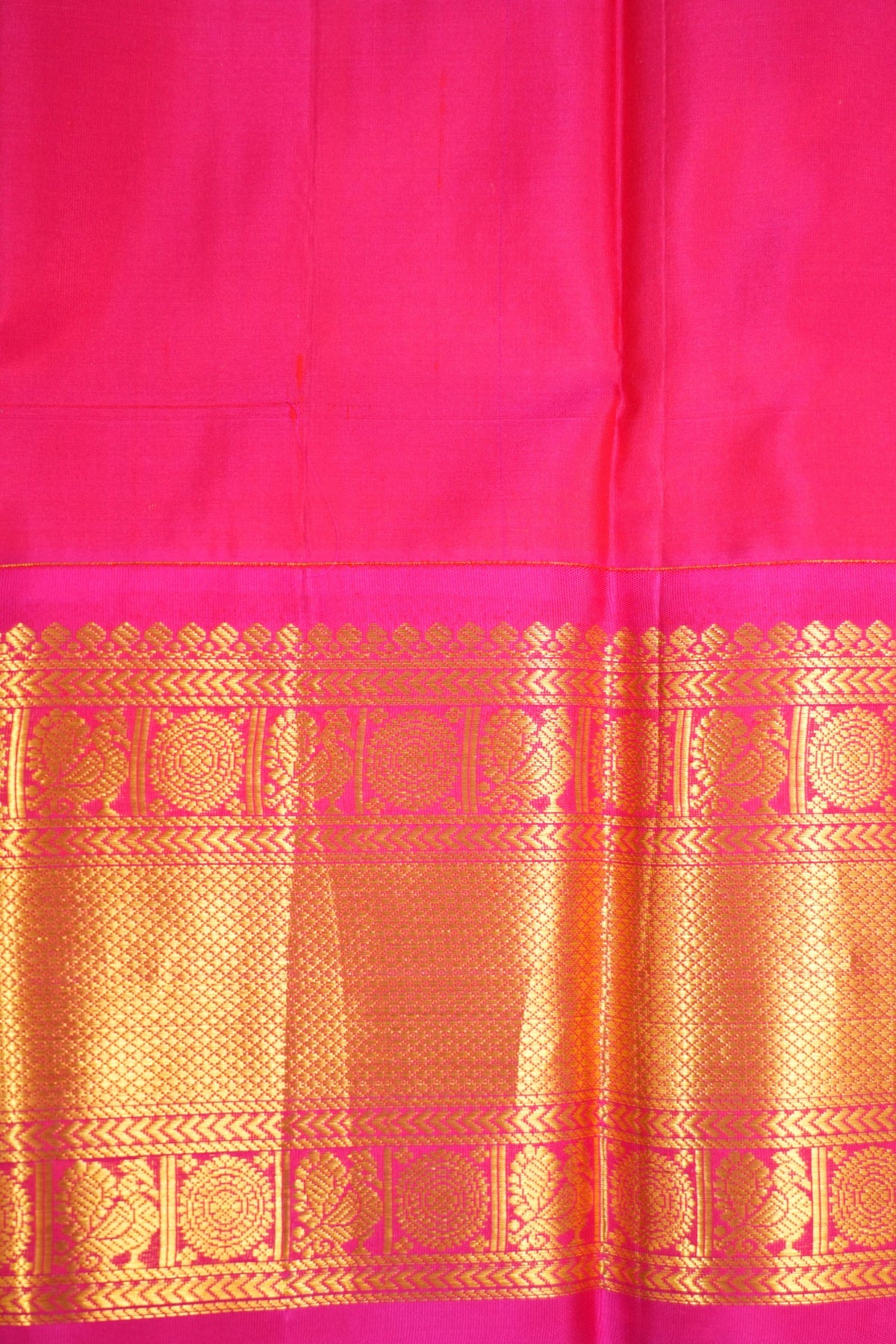 Warm Terracotta Sienna Kanjivaram silk with rich Magenta, featuring Peacock and Rudraksha motifs framed by elegant running leaf zari borders.