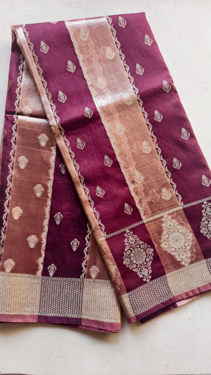 A luxurious Banarasi viscose silk saree in a rich deep wine-maroon shade, featuring intricate traditional motifs and elegant metallic-toned borders.
