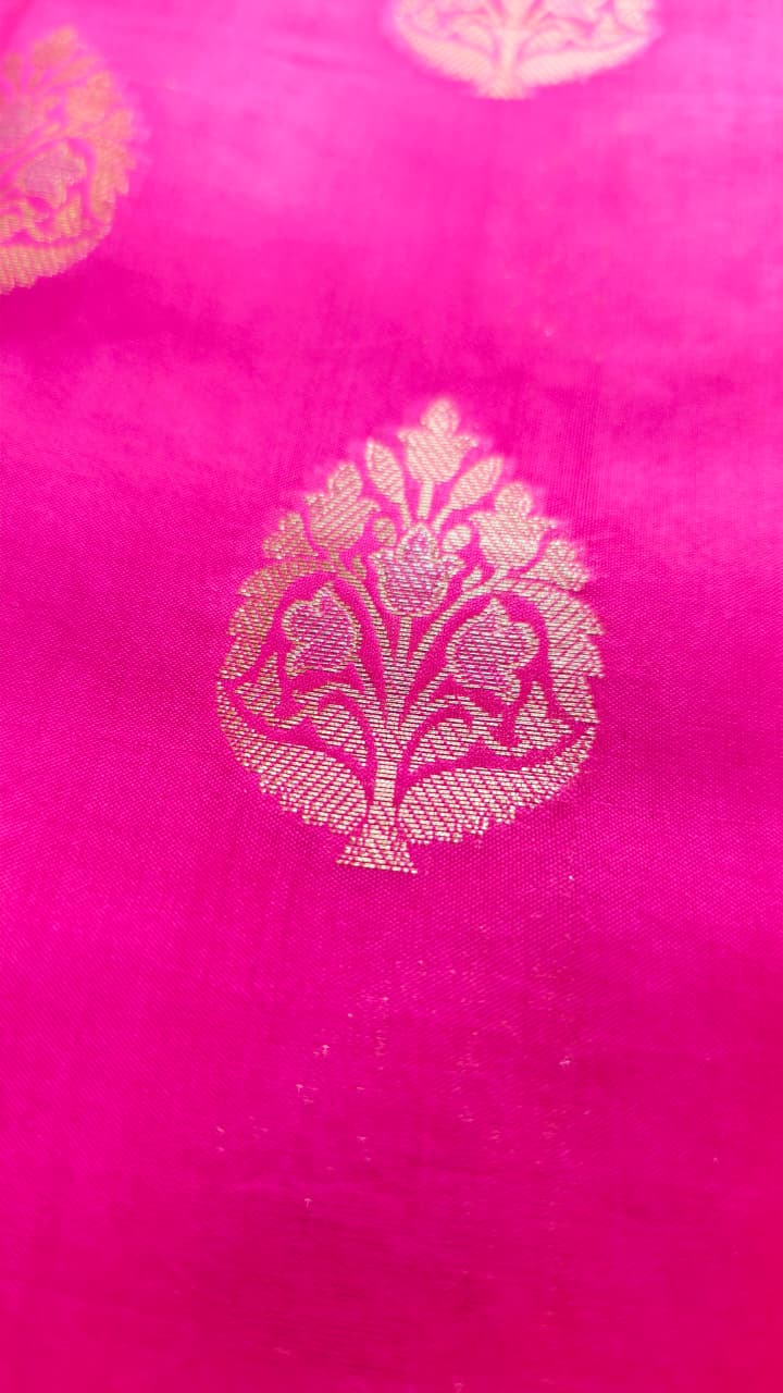 A rich Rani Pink Pure Silk Mark Certified Katan Chiniya Silk Banarasi saree, featuring intricate traditional Banarasi weaving and elegant motifs.