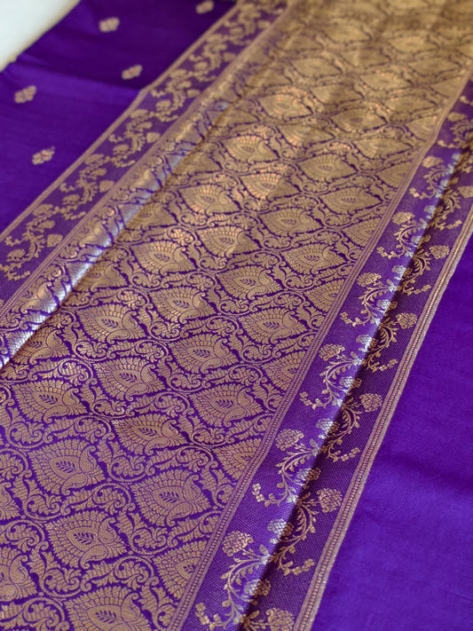 A regal Purple Banarasi viscose silk saree featuring intricate Minakari weaving, delicate traditional butis and an ornate floral pallu.