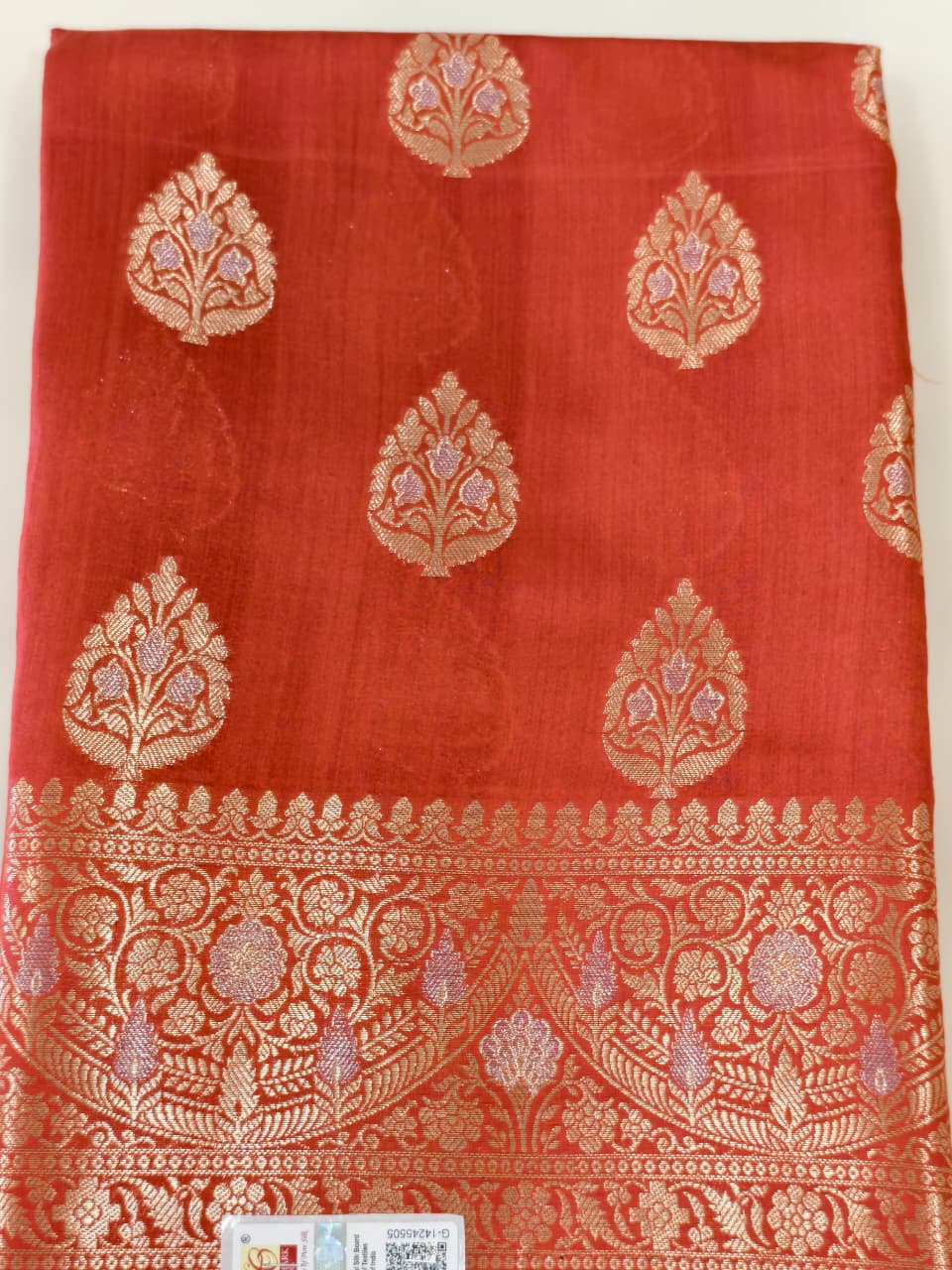 A rich Ruby Red Pure Silk Mark Certified Katan Chiniya Silk Banarasi Saree, featuring intricate traditional Banarasi weaving and elegant Chiniya-inspired motifs.
