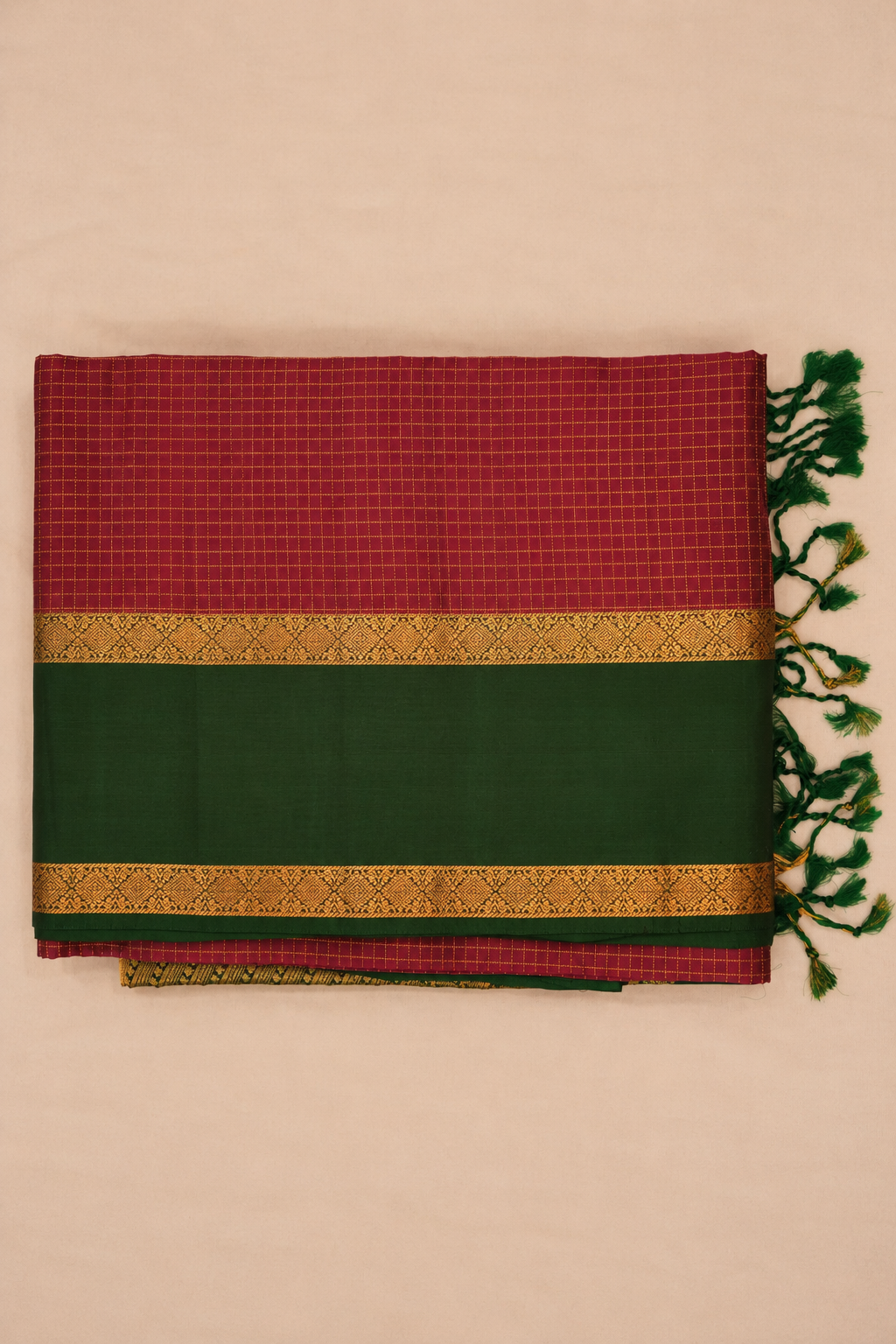Elegant wine-maroon pure soft silk with a striking dark green border enriched with intricate gold zari diamond motifs.