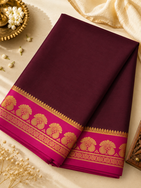Elegant wine-maroon Mysore Crepe silk enriched with traditional gold zari and graceful twin-peacock-inspired border motifs.