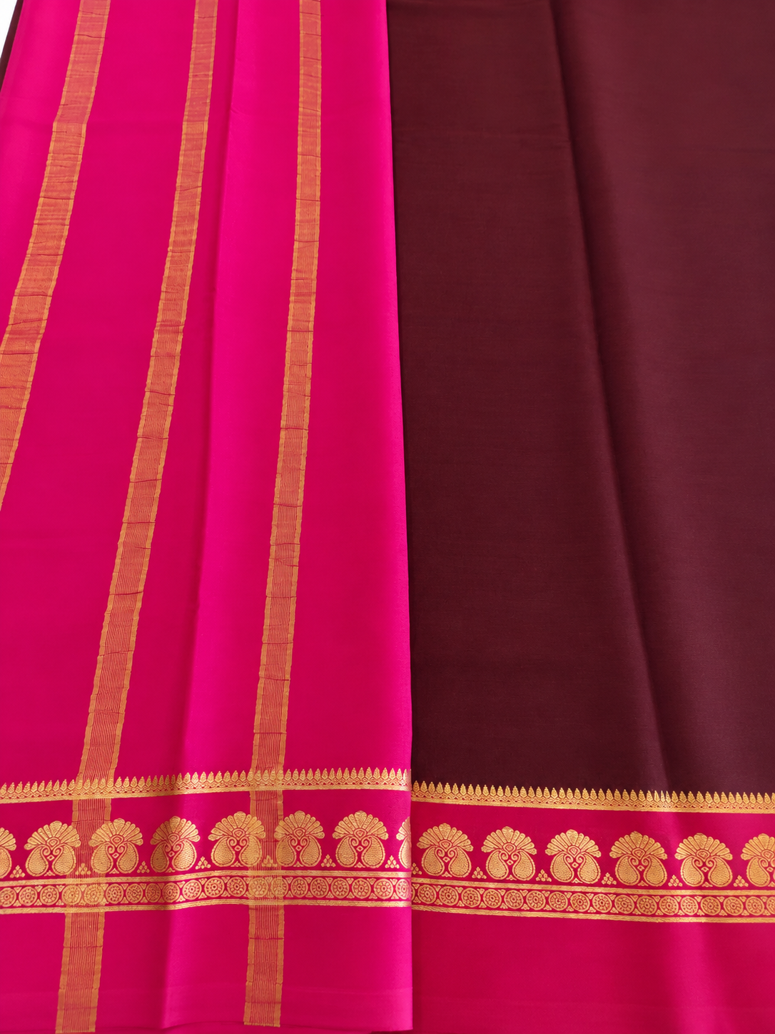 Elegant wine-maroon Mysore Crepe silk enriched with traditional gold zari and graceful twin-peacock-inspired border motifs.