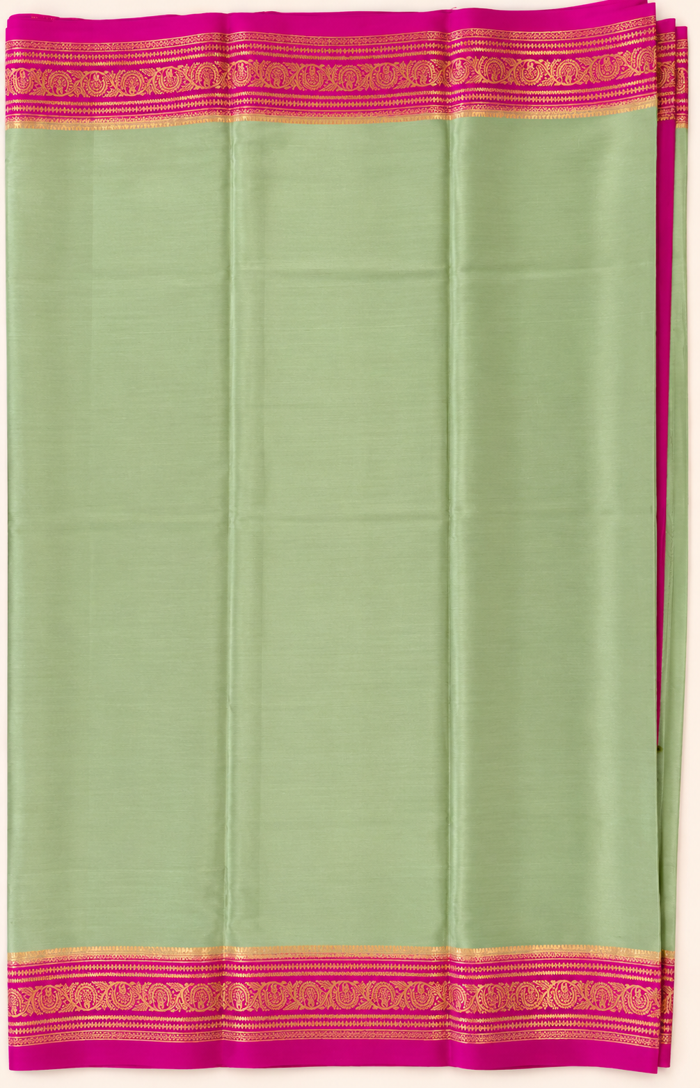 legant pastel green Pure Mysore Silk Crepe with a vibrant Rani Pink pallu and intricate floral gold zari borders.