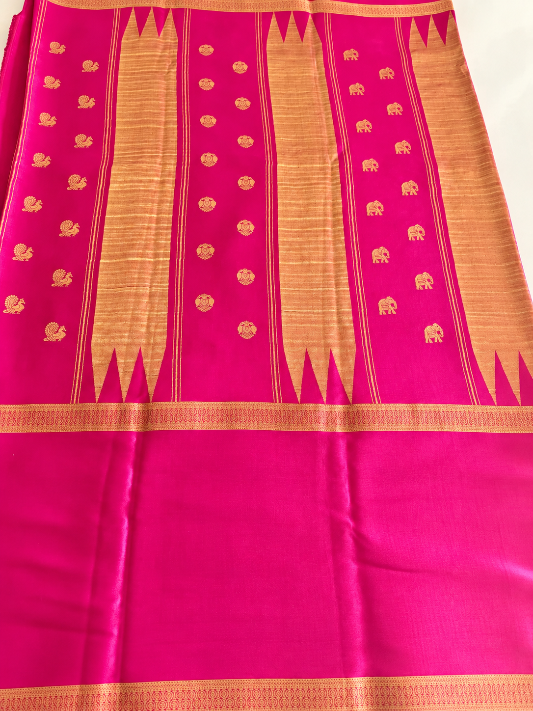 Rich magenta Mysore Crepe silk adorned throughout with Peacock, Gandaberunda, Topi and Elephant motifs in exquisite gold zari.
