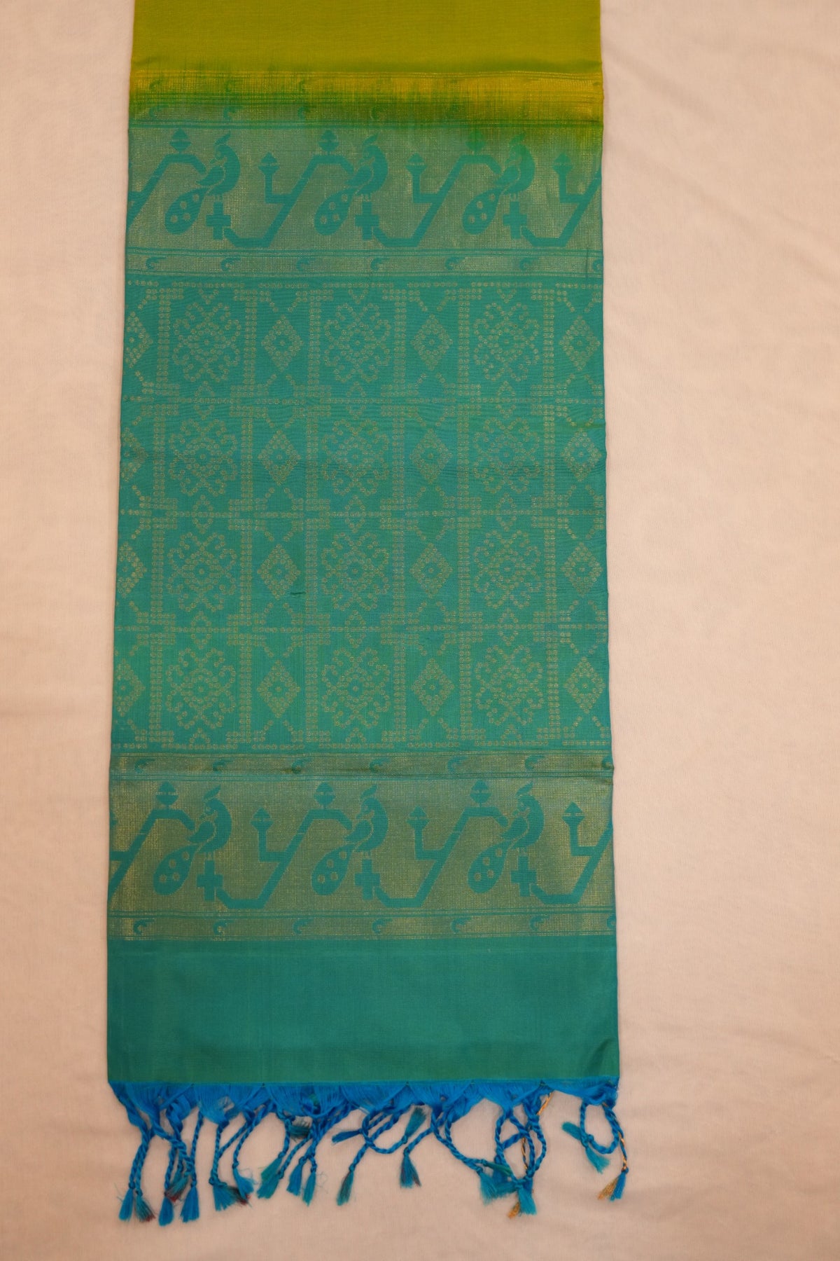 Vibrant lime green pure soft silk paired with teal blue, featuring elegant Paithani-inspired peacock motifs and traditional zari detailing.