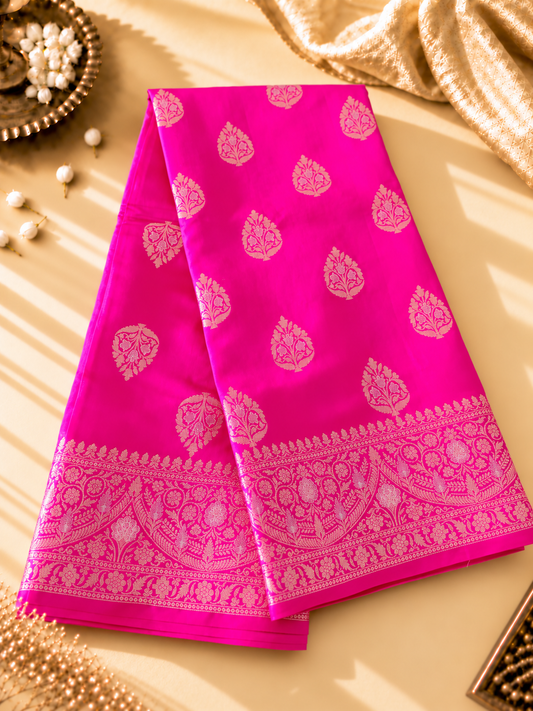 A rich Rani Pink Pure Silk Mark Certified Katan Chiniya Silk Banarasi saree, featuring intricate traditional Banarasi weaving and elegant motifs.