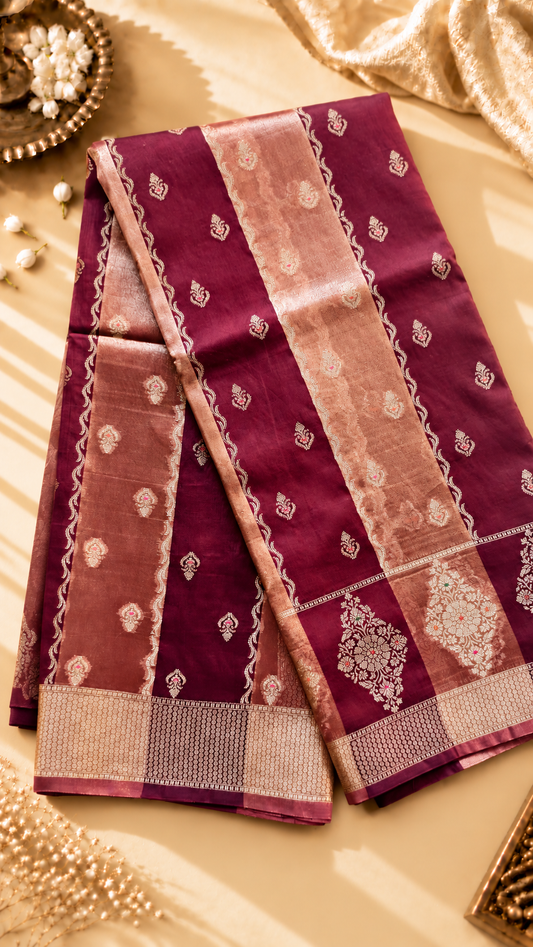 A luxurious Banarasi viscose silk saree in a rich deep wine-maroon shade, featuring intricate traditional motifs and elegant metallic-toned borders.