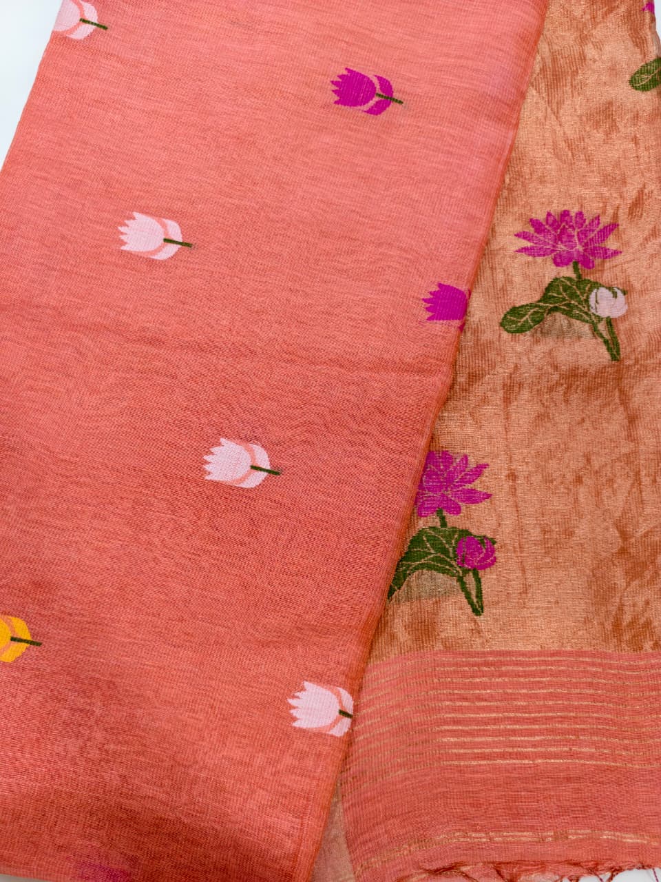 Handwoven Pure Tissue Linen Jamdani in warm burnt orange, adorned with vibrant floral motifs and delicate tissue zari detailing.
