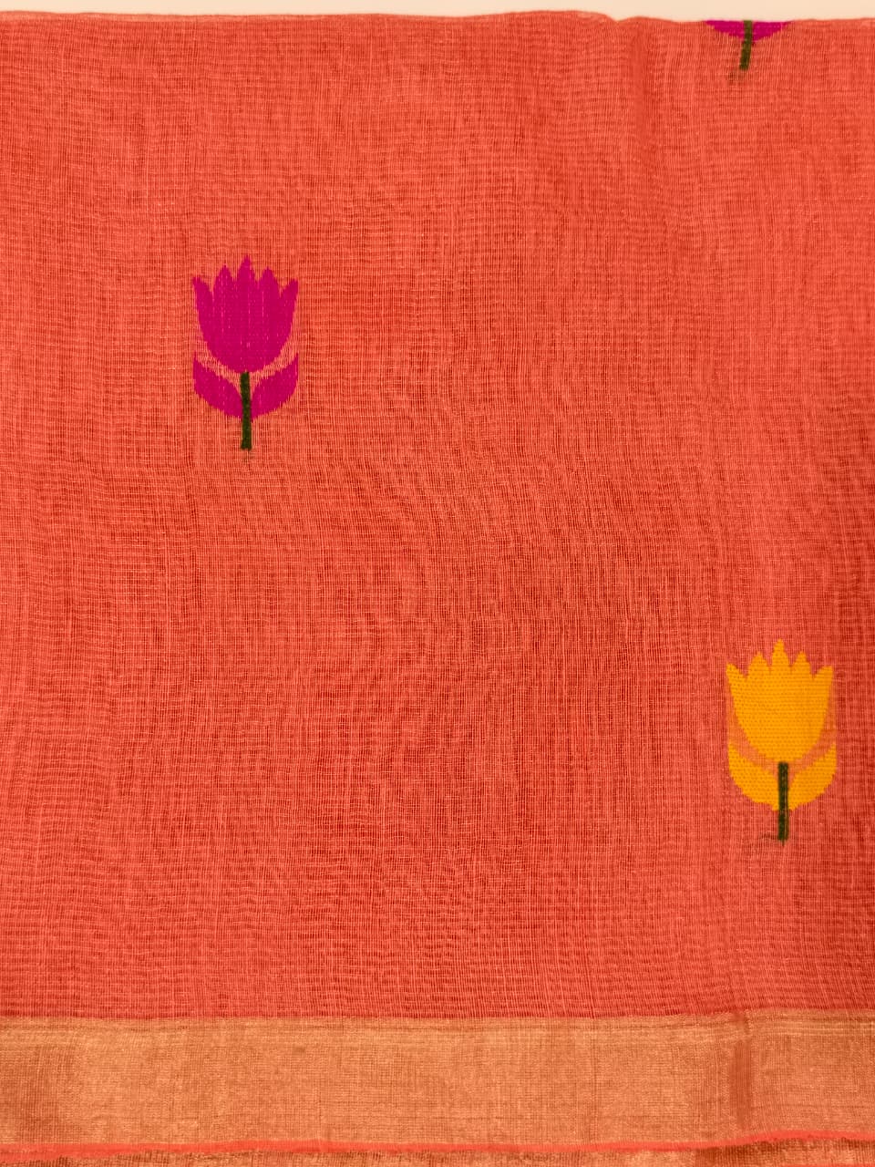 Handwoven Pure Tissue Linen Jamdani in warm burnt orange, adorned with vibrant floral motifs and delicate tissue zari detailing.