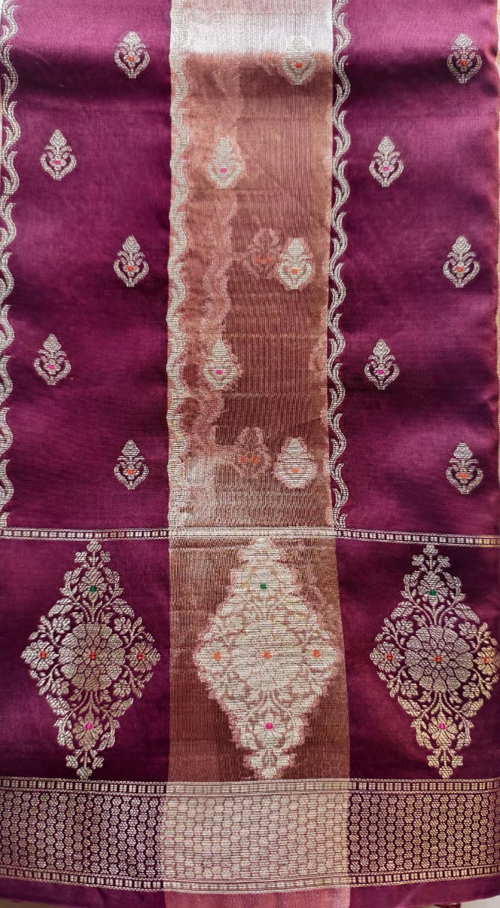 A luxurious Banarasi viscose silk saree in a rich deep wine-maroon shade, featuring intricate traditional motifs and elegant metallic-toned borders.