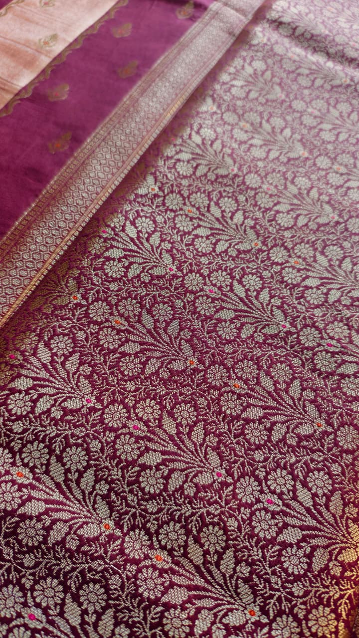 A luxurious Banarasi viscose silk saree in a rich deep wine-maroon shade, featuring intricate traditional motifs and elegant metallic-toned borders.