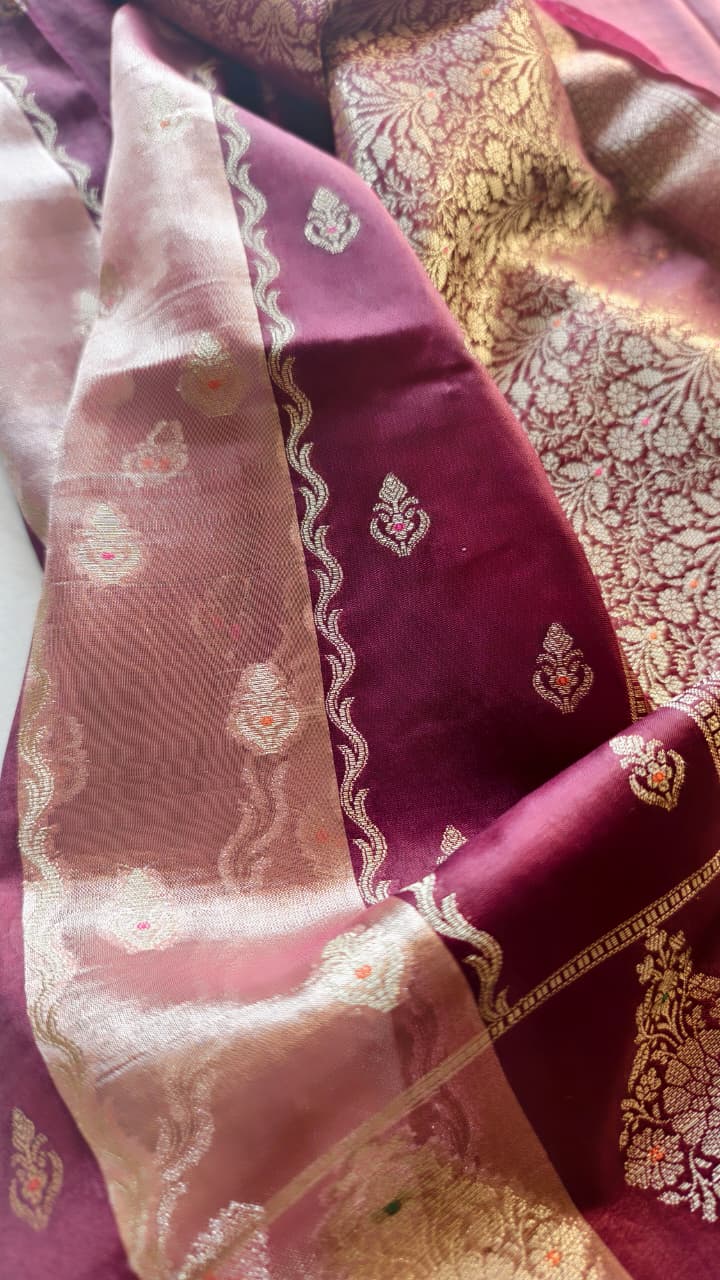 A luxurious Banarasi viscose silk saree in a rich deep wine-maroon shade, featuring intricate traditional motifs and elegant metallic-toned borders.