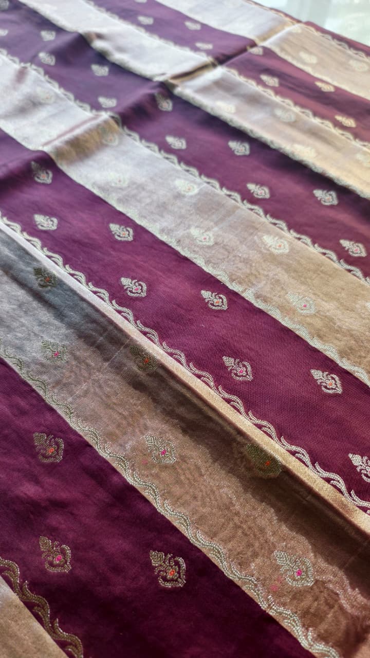 A luxurious Banarasi viscose silk saree in a rich deep wine-maroon shade, featuring intricate traditional motifs and elegant metallic-toned borders.