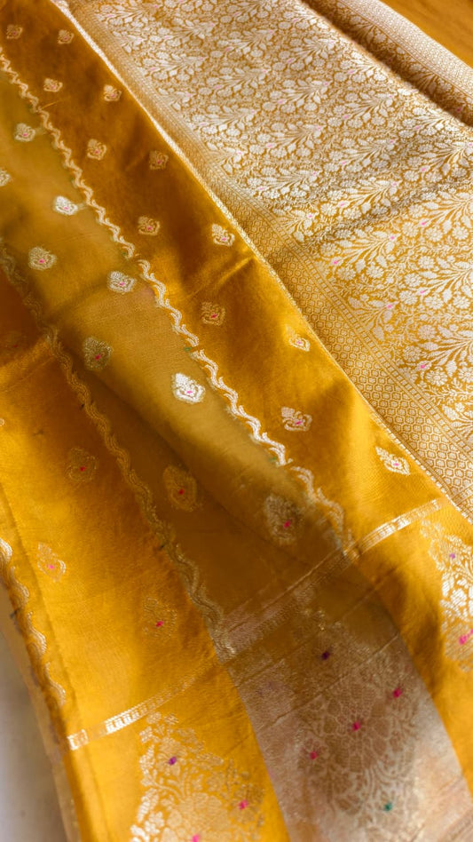A luxurious Banarasi viscose silk saree in a rich mustard-gold shade, featuring intricate all-over Minakari weaving with delicate pink and green accent