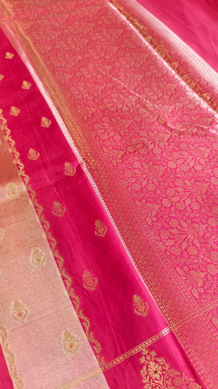 A luxurious Fuchsia Pink Banarasi viscose silk saree featuring intricate all-over Minakari weaving with delicate contrasting accents.