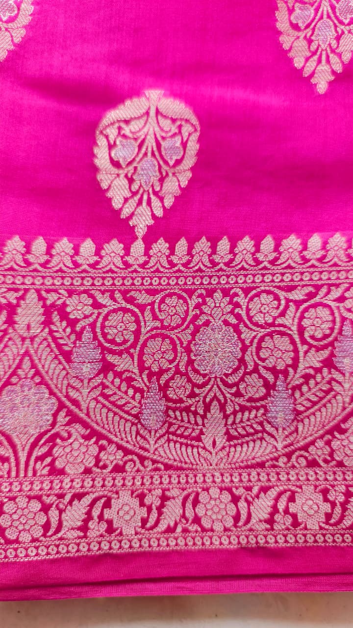 A rich Rani Pink Pure Silk Mark Certified Katan Chiniya Silk Banarasi saree, featuring intricate traditional Banarasi weaving and elegant motifs.
