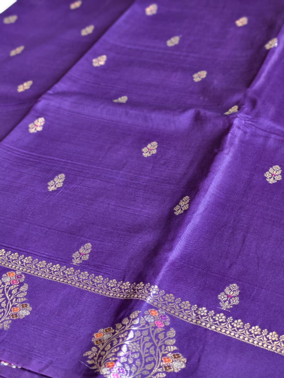 A regal Purple Banarasi viscose silk saree featuring intricate Minakari weaving, delicate traditional butis and an ornate floral pallu.