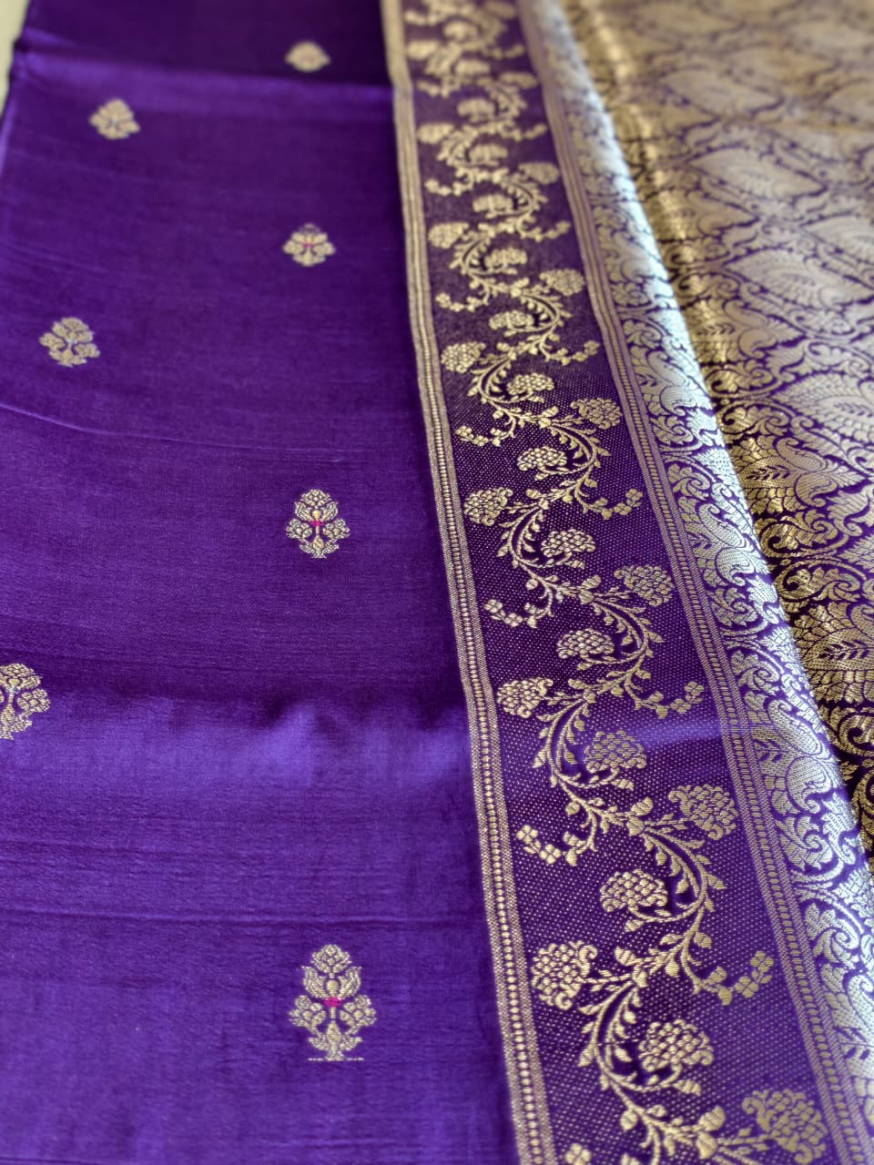 A regal Purple Banarasi viscose silk saree featuring intricate Minakari weaving, delicate traditional butis and an ornate floral pallu.