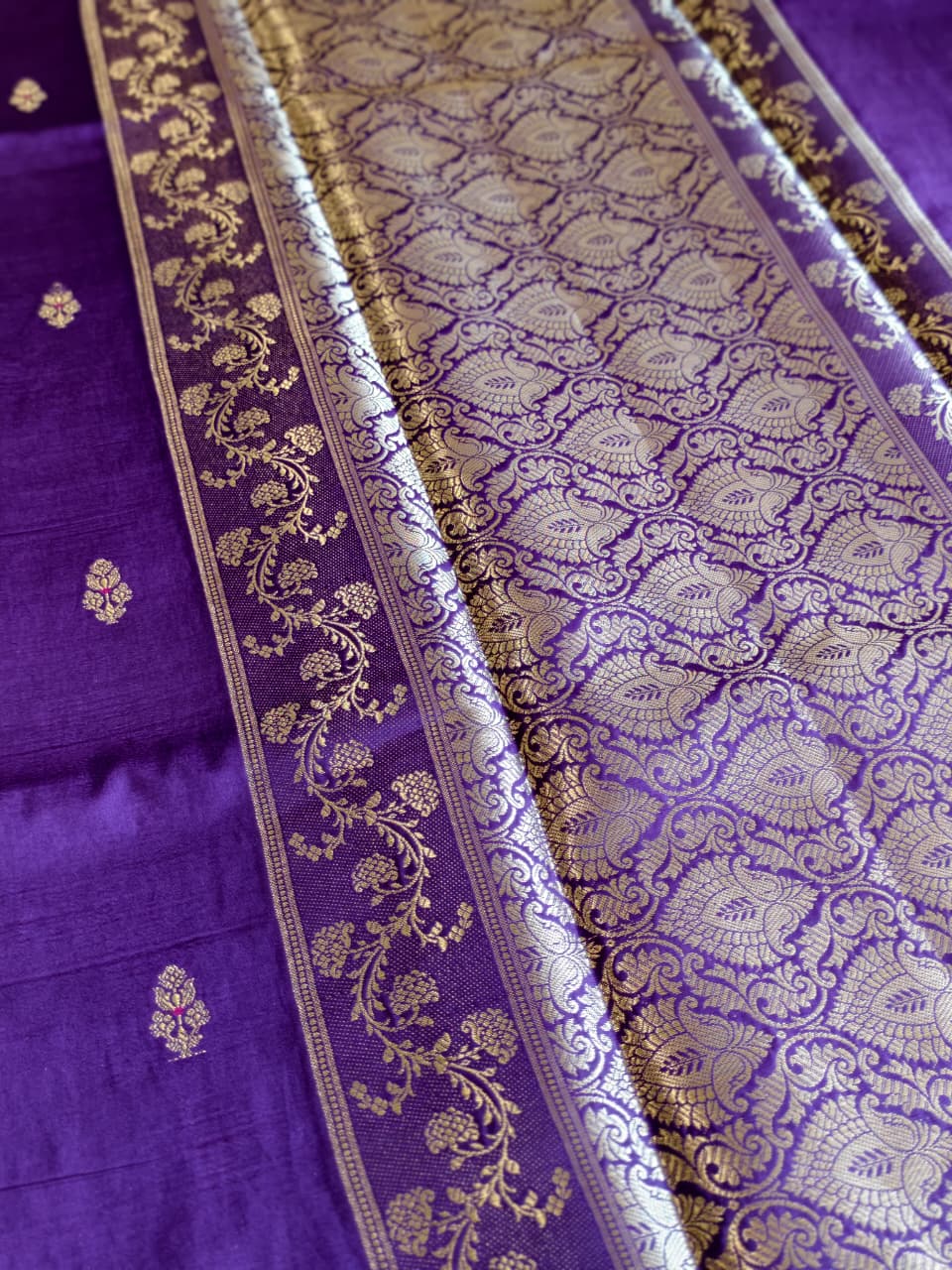 A regal Purple Banarasi viscose silk saree featuring intricate Minakari weaving, delicate traditional butis and an ornate floral pallu.