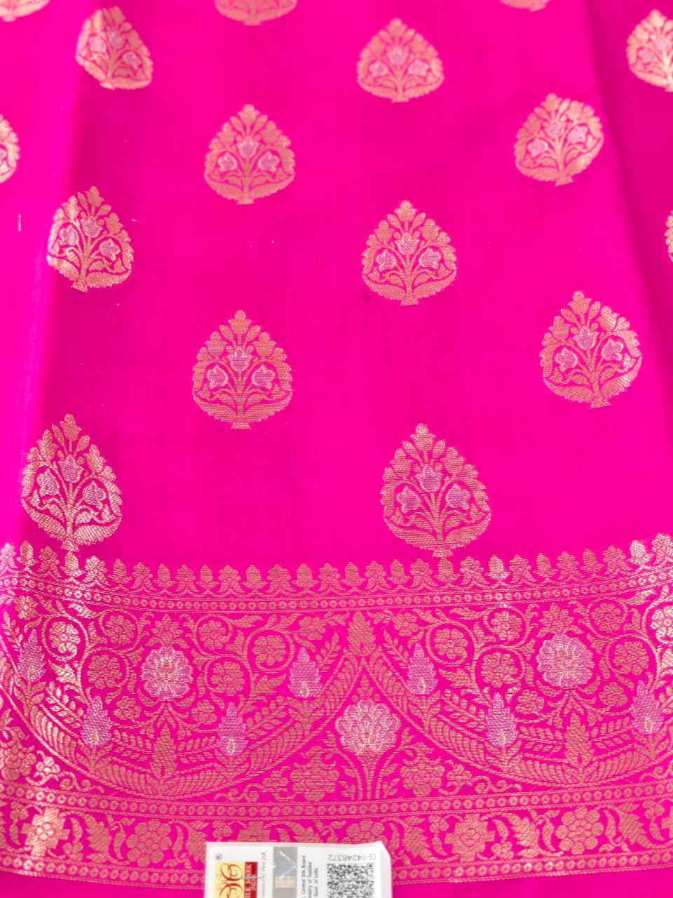 A rich Rani Pink Pure Silk Mark Certified Katan Chiniya Silk Banarasi saree, featuring intricate traditional Banarasi weaving and elegant motifs.