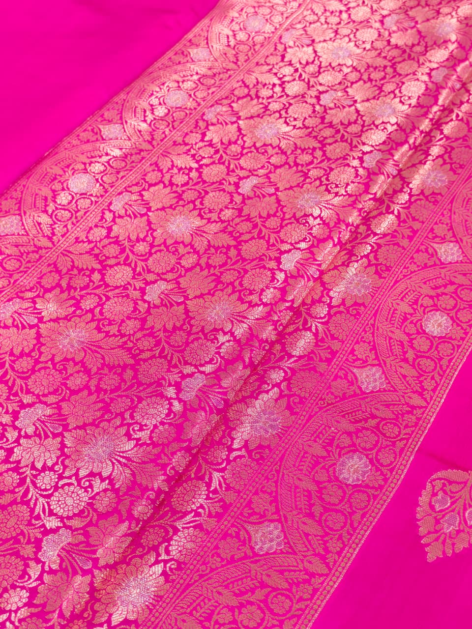 A rich Rani Pink Pure Silk Mark Certified Katan Chiniya Silk Banarasi saree, featuring intricate traditional Banarasi weaving and elegant motifs.