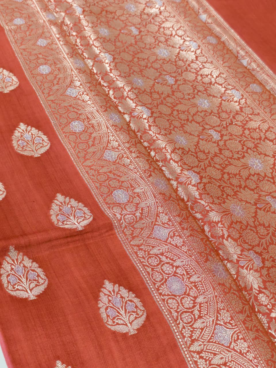 A rich Ruby Red Pure Silk Mark Certified Katan Chiniya Silk Banarasi Saree, featuring intricate traditional Banarasi weaving and elegant Chiniya-inspired motifs.