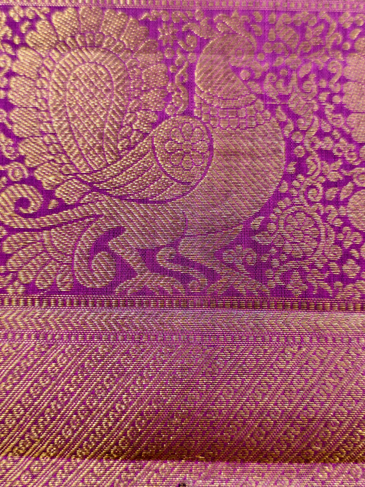 Pure Kanjivaram silk in regal royal MS blue, adorned with traditional gold motifs, an intricate zari border and a striking magenta edge. Silk Mark Certified.