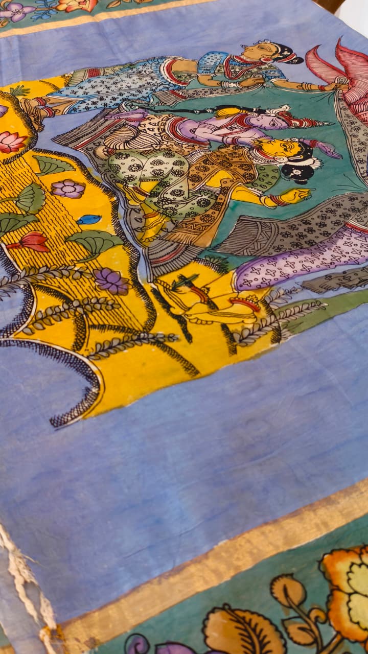 Hand-painted Kalamkari saree in Bangalore Silk featuring Rama & Sita on the body, Krishna & Radha on the pallu, floral borders, and a matching lavendar lotus-motif blouse piece