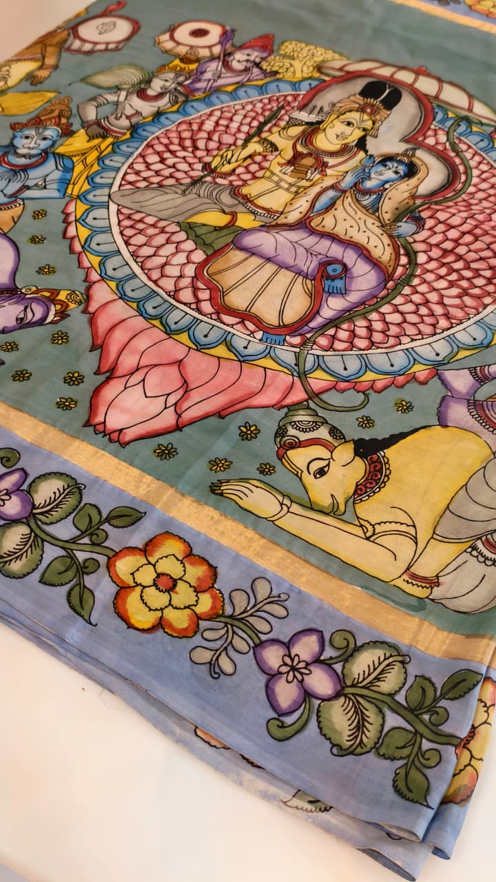 Hand-painted Kalamkari saree in Bangalore Silk featuring Rama & Sita on the body, Krishna & Radha on the pallu, floral borders, and a matching lavendar lotus-motif blouse piece