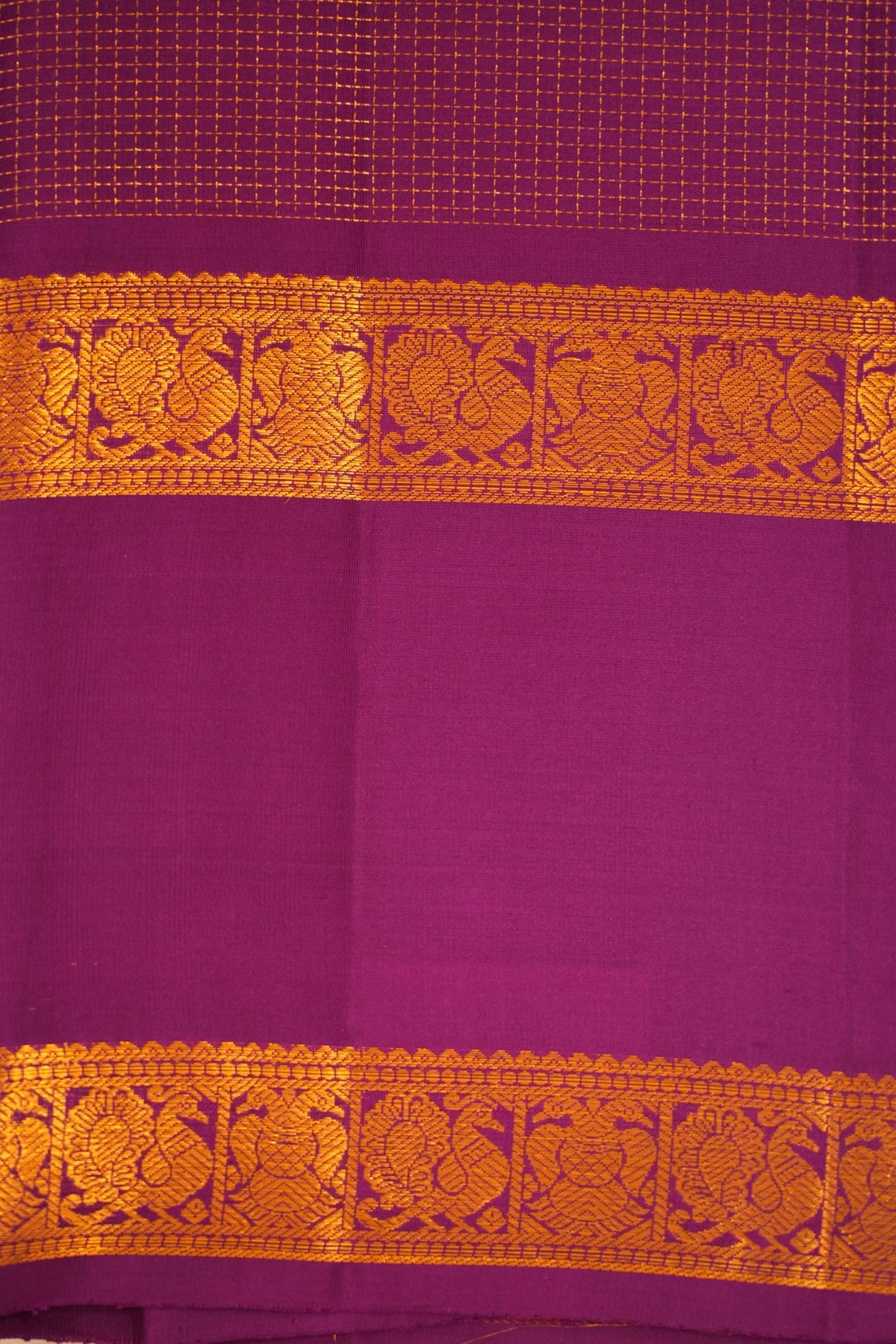 Regal royal purple Kanjivaram silk with gold zari checks, Gandaberunda, peacock motifs and intricate traditional line detailing.