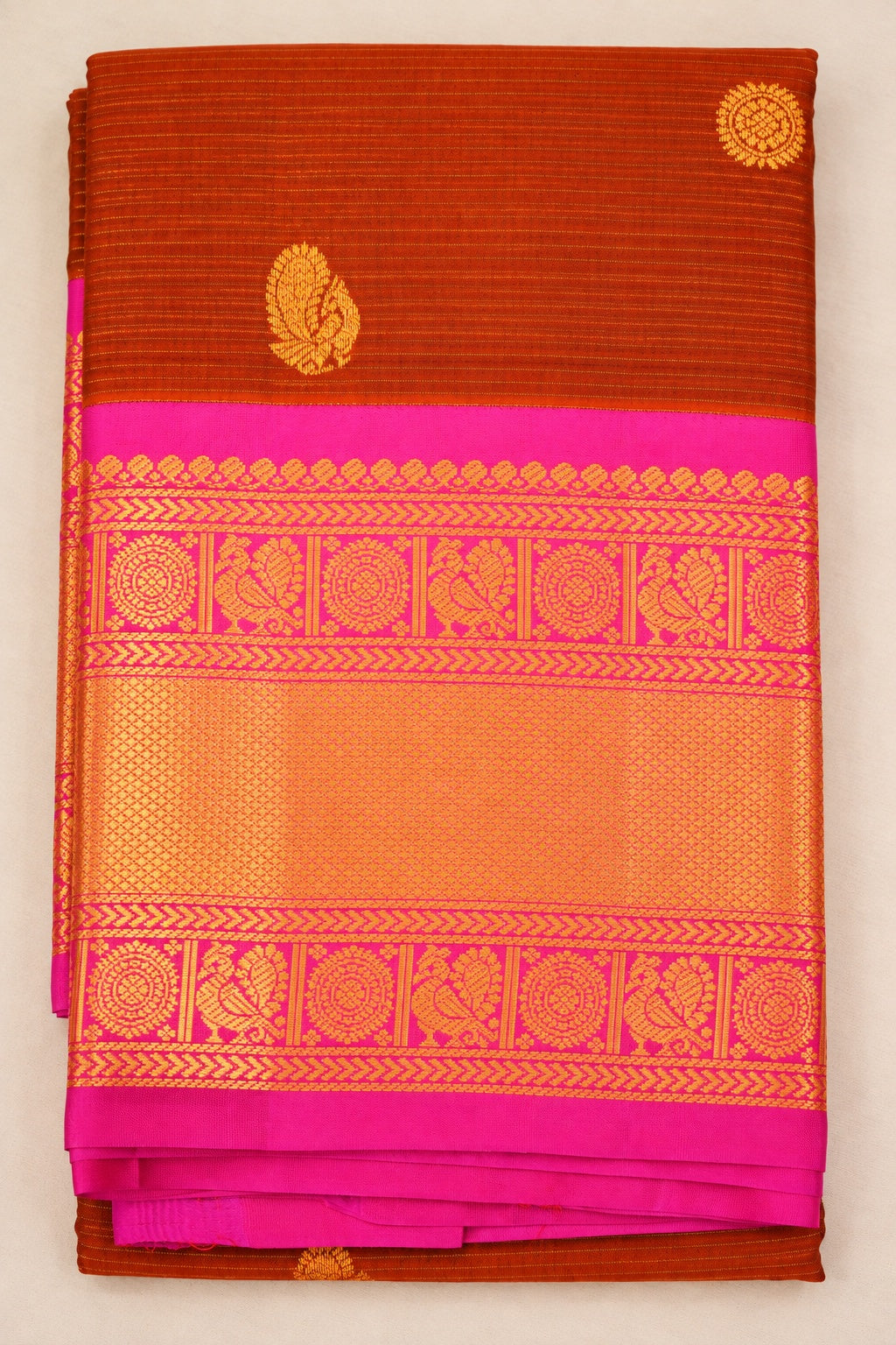 Warm Terracotta Sienna Kanjivaram silk with rich Magenta, featuring Peacock and Rudraksha motifs framed by elegant running leaf zari borders.